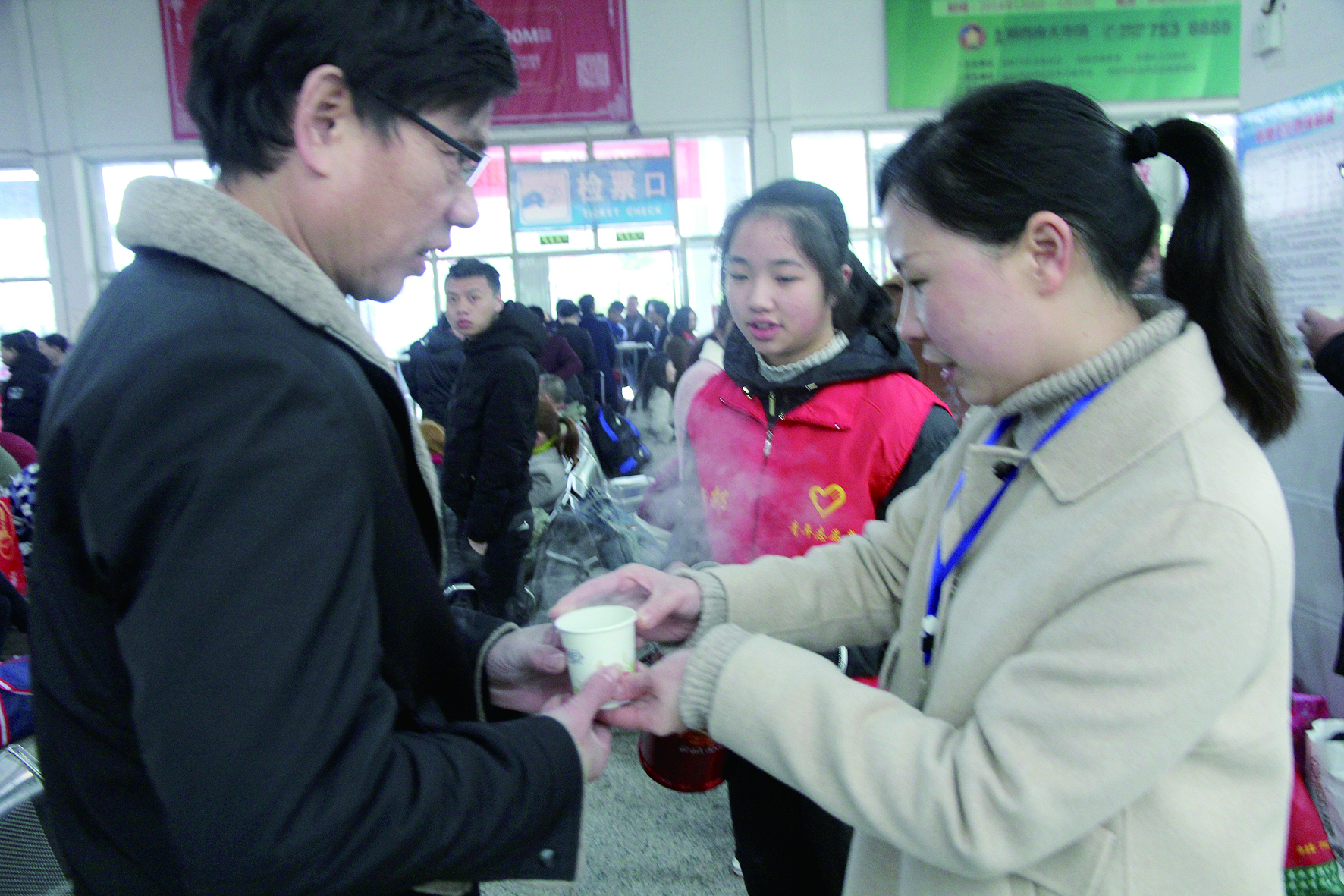 母女服務(wù)春運(yùn) 2月13日，記者在新邵分公司汽車站看到，該分公司安全科副科長李喜梅與其在新邵一中初中部1701班就讀女兒劉嘉怡在車站擔(dān)當(dāng)志愿者。李喜梅在候車室耐心為旅客釋疑解惑，劉嘉怡為旅客遞上一杯杯熱茶，有時(shí)母女也相互合作，其樂融融。 祖冠 攝影報(bào)道